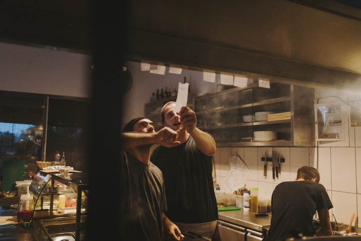 Cooks preparing food in busy restaurant kitchen