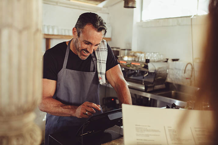 Restaurant owner rings up customer at counter